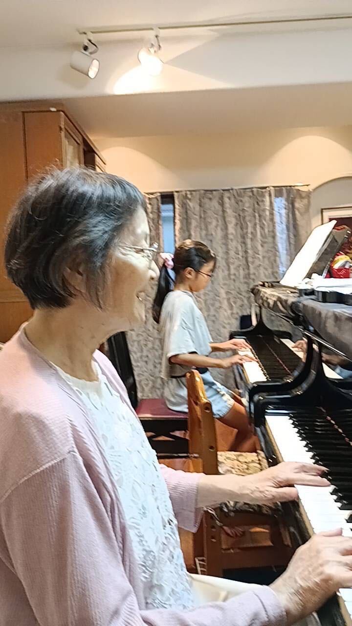 2台のグランドピアノで生徒と一緒に演奏する中嶋恵理先生